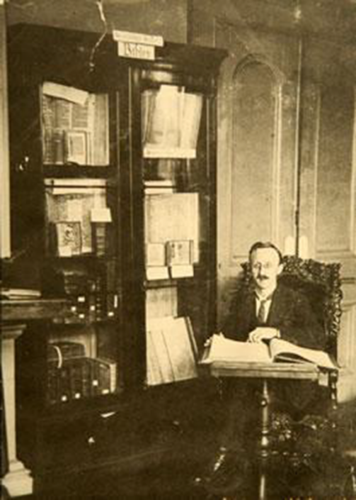 Arthur Ezekiel Gower was the Librarian at the time of this picture, in 1922. He is pictured in front of the Bible bookcases which were part of the Gibson bequest