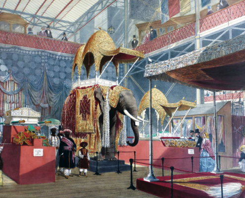 An 1851 lithograph showing the Indian display at the Crystal Palace Great Exhibition, featuring a massive taxidermy elephant under a golden canopy surrounded by Victorian visitors.