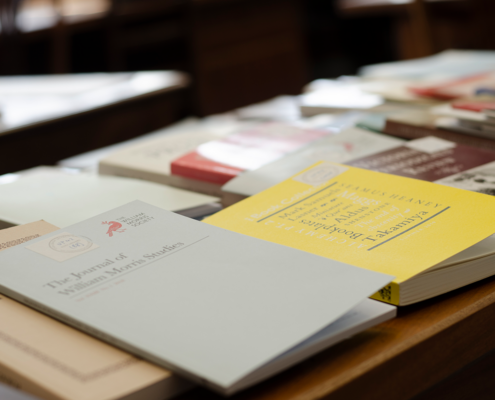 image of different covered books on a wooden desk.