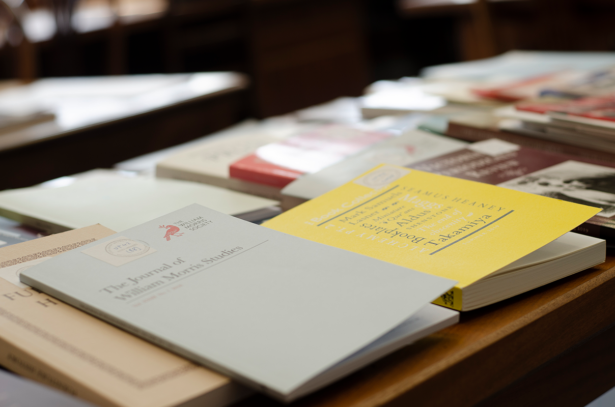 image of different covered books on a wooden desk.