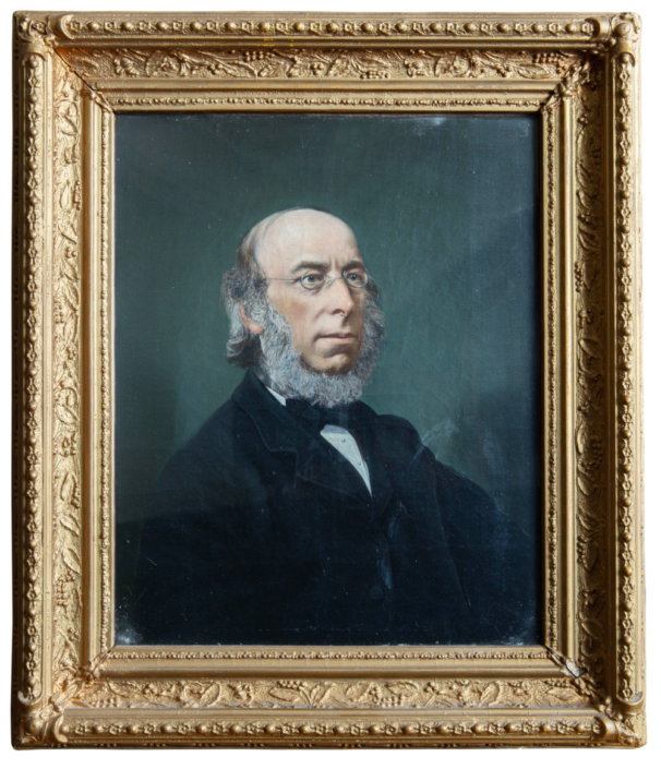 A gold-framed 19th-century oil portrait of George Stacey Gibson, showing him in spectacles and a formal black suit against a dark background.