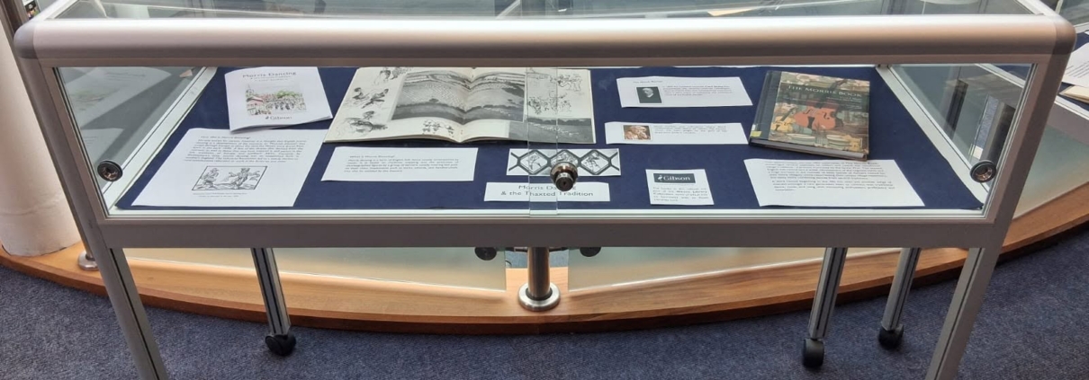 A Gibson Library exhibition display cabinet featuring various books and exhibition cards