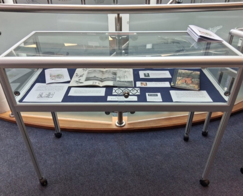 A Gibson Library exhibition display cabinet featuring various books and exhibition cards